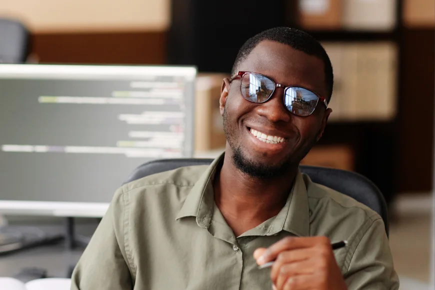 Développeur souriant à son poste de travail
